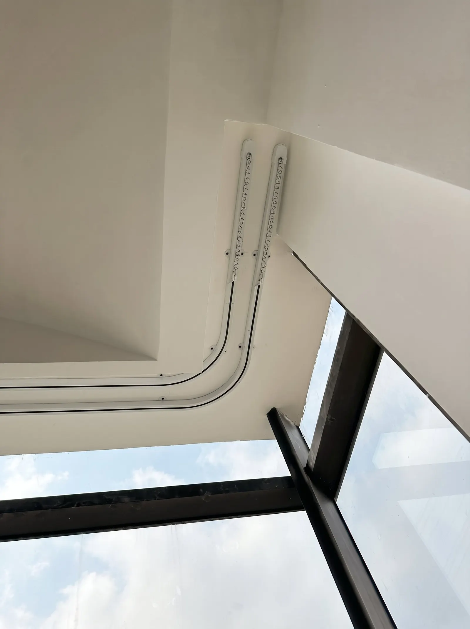 Ray rèm uốn cong âm trần chạy theo mép kính, lắp đặt thực tế